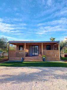 a log home with a porch and a house at Julija Mobile Lux in Vodice