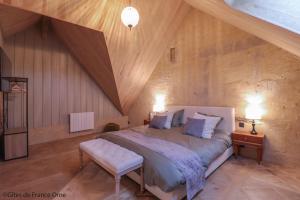 a bedroom with a large bed and a wooden ceiling at RELAI VALDIEU in Courgeon