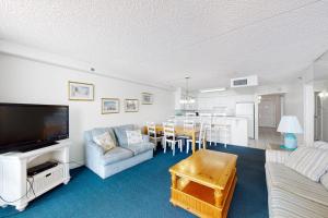 a living room with a couch and a tv and a table at Carousel 1905 in Ocean City