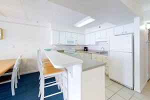 a kitchen with white cabinets and a white refrigerator at Carousel 1905 in Ocean City +15 photos