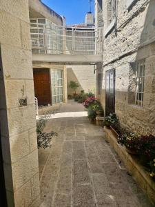 a courtyard of an old stone building with flowers at Kosher Villa in earth of Moshava in Jerusalem