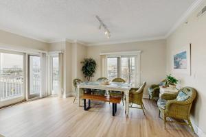 a dining room with a table and chairs and windows at Condo 4100 #201 in Ocean City