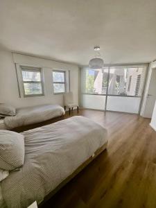 a bedroom with two beds and a large window at Kosher Villa in earth of Moshava in Jerusalem