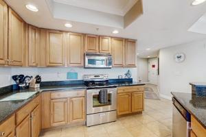 a kitchen with wooden cabinets and a stove top oven at Condo 4100 #201 in Ocean City +16 photos
