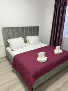 a bedroom with a bed with white shoes on it at C&A Apartment in Giroc