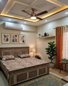a bedroom with a large bed with a ceiling fan at Shabbir Premier Heights in Lahore +5 photos