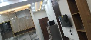 a bathroom with a refrigerator and a tv on the wall at Shabbir Premier Heights in Lahore
