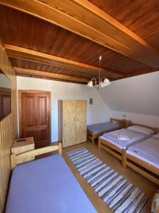 two beds in a room with wooden ceilings at Penzion Mühl in Bedřichov +29 photos