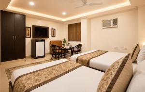 a hotel room with two beds and a table at HOTEL DAKHA INTERNATIONAL - Karol Bagh, New Delhi in New Delhi +21 photos