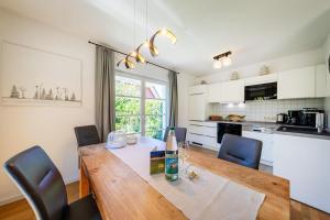 a kitchen and dining room with a wooden table and chairs at Haus Sonnenschein 2 in Ahrenshoop