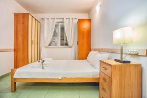 a bedroom with a bed and a lamp and a window at Apartment SM in Herceg-Novi