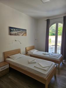 two beds in a room with a window at Villa Ponta in Buljarica