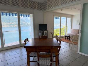 a dining room with a table and views of the ocean at Orizzonte Blu by HolAp SA in Gambarogno