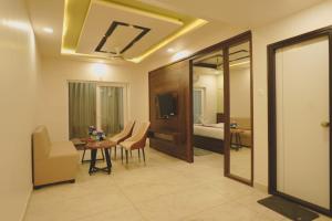 a living room with a table and chairs and a bedroom at Hotel Ayodhya Inn in Lokāpur