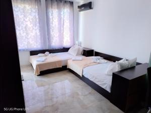 a bedroom with two beds and a window at Апартамент 310 in Primorsko +47 photos