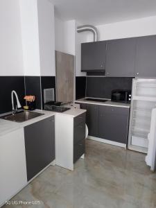 a kitchen with gray and white cabinets and a sink at Апартамент 310 in Primorsko