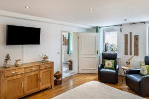 a living room with a television and a chair at Ferienwohnung An der Wublitz in Leest