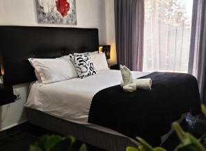 a bedroom with a bed with black and white pillows at Nylstroom Guesthouse in Modimolle