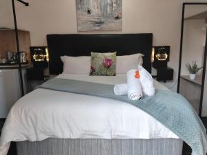 a bedroom with a bed with two towels on it at Nylstroom Guesthouse in Modimolle +6 photos