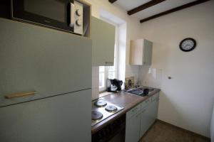 a kitchen with a refrigerator and a clock on the wall at NEU! Wohnung Balkenzimmer in Alsfeld
