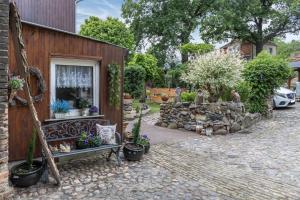 a garden with potted plants next to a building at Ferienwohnung An der Wublitz in Leest