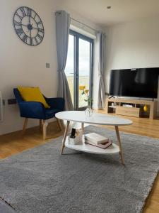 a living room with a coffee table and a clock at Modern 2 Bed Flat, Free Parking, Central Hemel in Hemel Hempstead