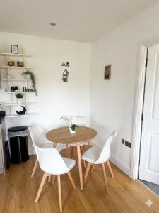 a dining room with a wooden table and white chairs at Modern 2 Bed Flat, Free Parking, Central Hemel in Hemel Hempstead
