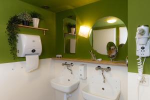 a bathroom with two sinks and a mirror at Hostel Ani&Haakien in Rotterdam +49 photos