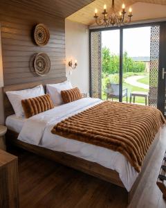 a bedroom with a large bed with a large window at Zen Resort & SPA in Purcari