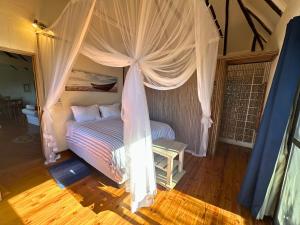 a bedroom with a bed with a canopy at Kangela 14 in Ponta Malangane