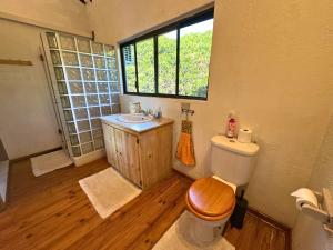 a bathroom with a toilet and a sink and a window at Kangela 14 in Ponta Malangane +12 photos