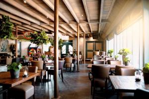 a restaurant with wooden ceilings and tables and chairs at EuroParcs Kaatsheuvel in Kaatsheuvel