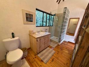 a bathroom with a toilet and a sink and a shower at Kangela 14 in Ponta Malangane
