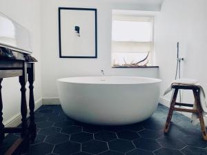 a white bath tub in a bathroom with a stool at Wester Auchraw Croft B&B in Lochearnhead