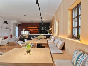 a living room with wooden tables and white chairs at Apartmány Pod Jabloní in Jablonné nad Orlicí