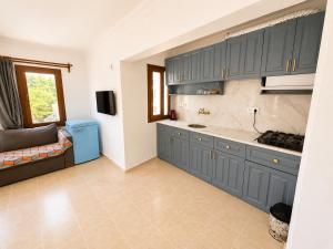 a kitchen with blue cabinets and a couch in a room at Kilim Hotel & Apart in Fethiye