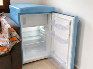 an open refrigerator with a blue lid next to a couch at Kilim Hotel & Apart in Fethiye