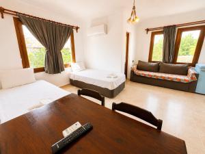 a room with two beds and a table and a couch at Kilim Hotel & Apart in Fethiye +69 photos
