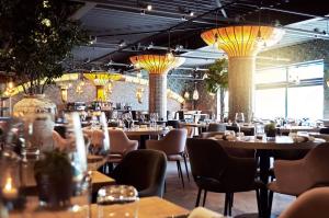 a restaurant with tables and chairs and chandeliers at EuroParcs Kaatsheuvel in Kaatsheuvel