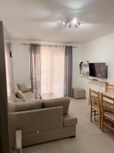 a living room with a couch and a table at SunSis Apartment in Shëngjin