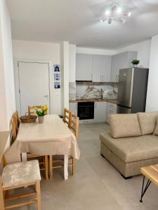 a kitchen and living room with a table and a couch at SunSis Apartment in Shëngjin