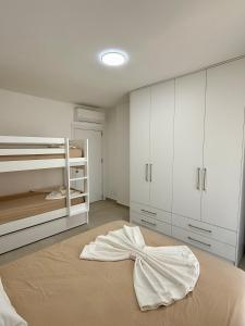 a bedroom with a bed with a bow on it at SunSis Apartment in Shëngjin +19 photos