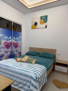 a bedroom with a bed with a blue comforter at AA Boutique Hotel in Shkodër