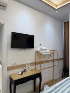 a room with a bed and a tv on a wall at AA Boutique Hotel in Shkodër
