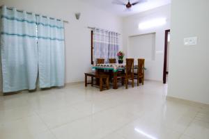 a dining room with a table and chairs at Aranya Ocean Breeze in Mangalore +11 photos