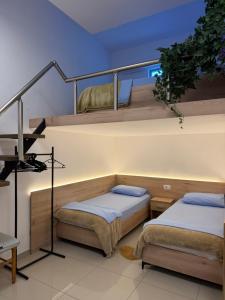 two beds in a room with a staircase at AA Boutique Hotel in Shkodër