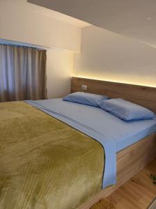 a bedroom with a bed with blue pillows on it at AA Boutique Hotel in Shkodër +10 photos