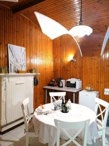 a kitchen with a white table and chairs and a table and a microwave at La Cà De Zan in Mezzegra