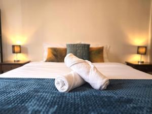 a pair of rolled up towels on a bed at LE MATIN CALME - Charme ancien - Vue canal in Dole