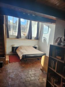 a bedroom with a bed in a room with a window at Le bateau sur les toits in Cotignac